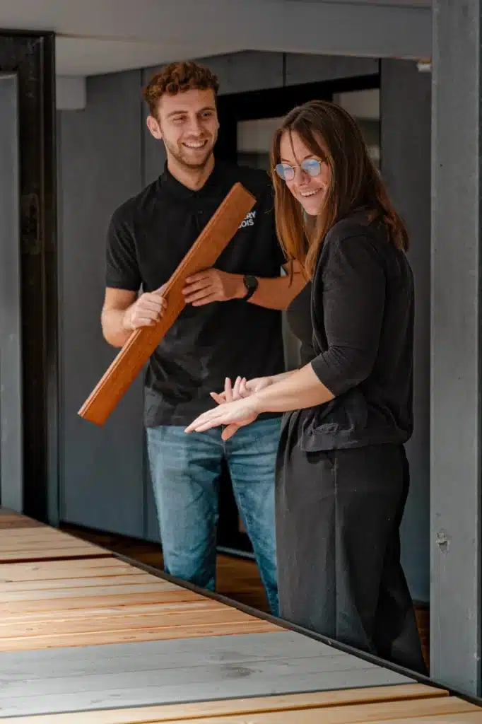 Un conseiller présente une lame de terrasse à une cliente